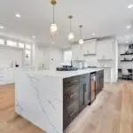 Modern Portland kitchen with wide-plank luxury vinyl flooring and white quartz countertops by Trinity Flooring